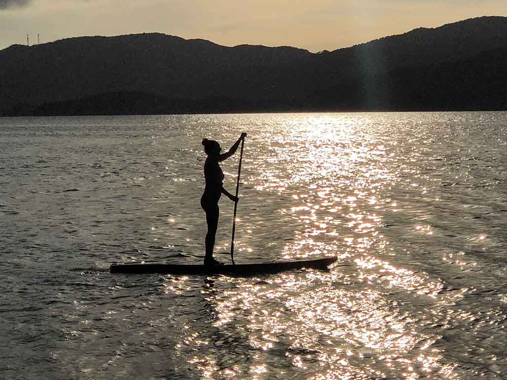 standup paddleboarding at sunset