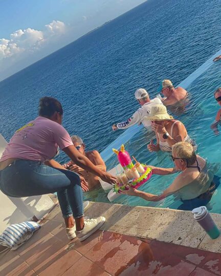 bartender serving guests in the infinity pool